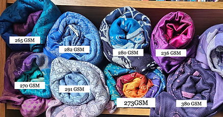 A variety of woven wraps labelled with their GSM