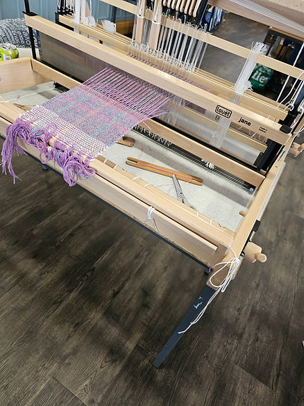 A piece of fabric being woven by hand