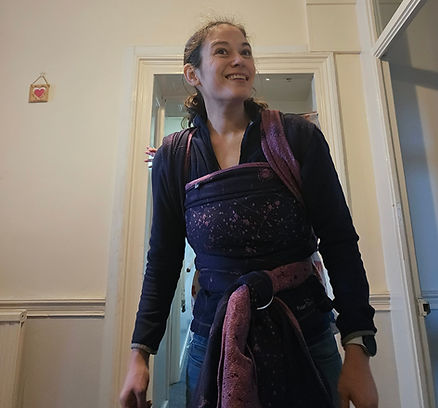 A woman wearing her baby in a firespiral sling