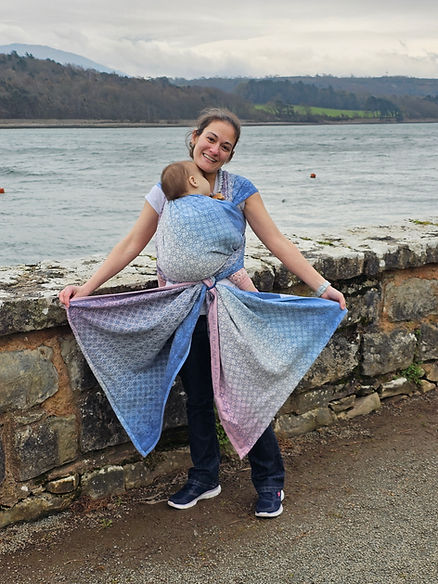 A woman carrying her baby on the front