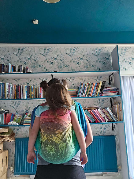 An image of a woman carrying her preschool aged child on her back