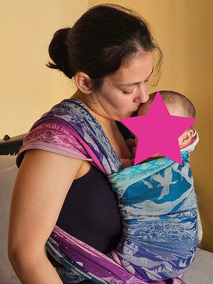 A woman carrying her baby on the front in a woven wrap